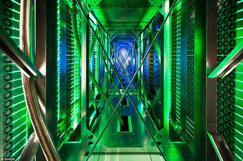 Here hundreds of fans funnel hot air from the server racks into a cooling unit to be recirculated in Oklahoma. The green lights are the server status LEDs reflecting from the front of the servers